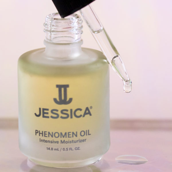 Open bottle of Phenomen Cuticle Oil with a glass dropper dispensing oil